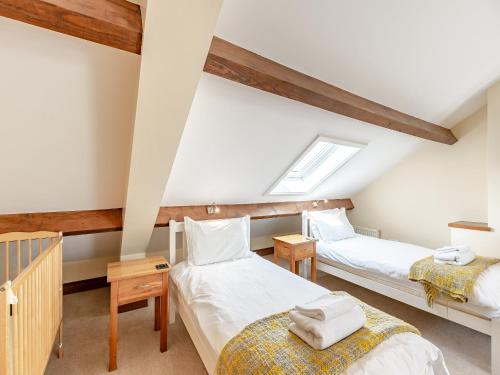 a attic bedroom with two beds and a skylight at Warth Barn - Uk44211 in Ingleton