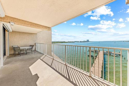 a balcony with a table and chairs and a view of the water at Compass Point 303 in Gulf Shores