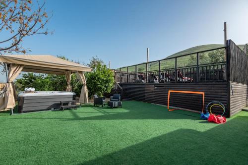a grassy yard with a gazebo and a soccer ball at וילה בין הר לכנרת in Yavneʼel