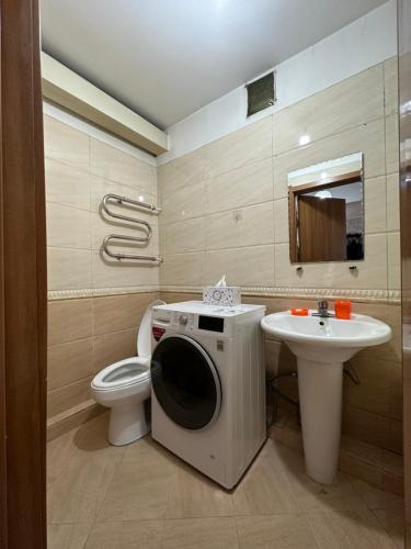 Łazienka z pralką obok toalety i umywalką w obiekcie Your home in UB w Ułan Bator