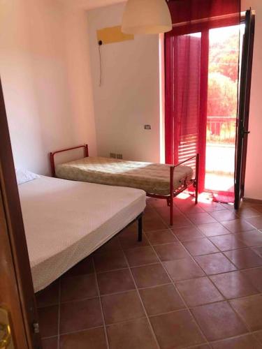 1 Schlafzimmer mit 2 Betten und einem Fenster mit Aussicht in der Unterkunft Villa Serena in Vibonati