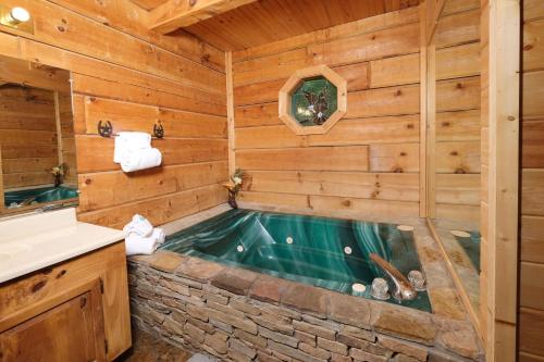 a jacuzzi tub in a log cabin bathroom at A Mountain Surprise in Pigeon Forge
