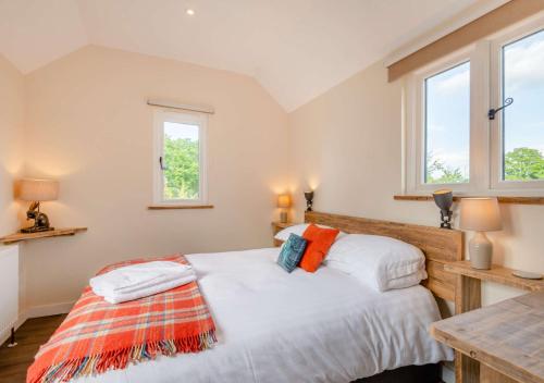 1 dormitorio con 1 cama y 2 ventanas en The Boathouse, en Biddenden
