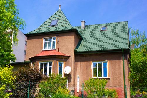 チェシンにあるDomek na Wzgórzuの緑屋根の大きなレンガ造りの家