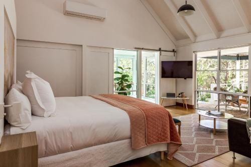 a bedroom with a large bed and a tv at Hideaway Studio in Dunsborough