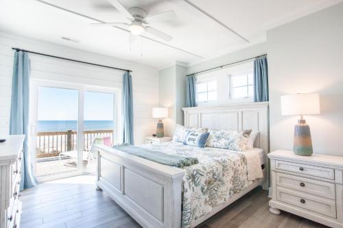 een slaapkamer met een bed en een balkon met uitzicht op de oceaan bij Gray Dolphin III in North Topsail Beach