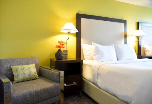 a hotel room with a bed and a chair at Stunning 12th Floor Studio In The Heart Of Grove in Miami