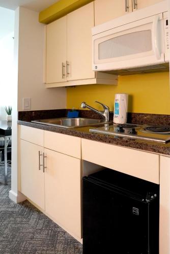 a kitchen with a sink and a microwave at Stunning 12th Floor Studio In The Heart Of Grove in Miami