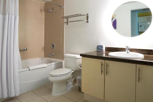 a bathroom with a toilet and a tub and a sink at Stunning 12th Floor Studio In The Heart Of Grove in Miami