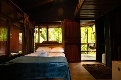 un dormitorio con una cama con un osito de peluche sentado en ella en River Song's Hotel, en Mindo
