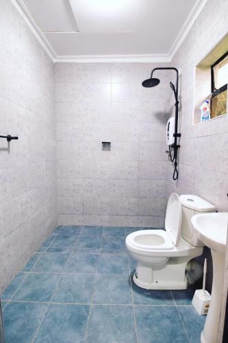 a bathroom with a toilet and a sink at Arabel's Place Riverside Villas in Nanyuki