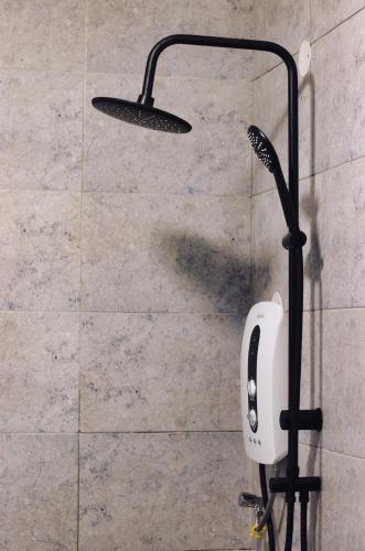 a shower with a soap dispenser on a wall at Arabel's Place Riverside Villas in Nanyuki