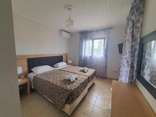a hotel room with a bed and a window at BELLA De LUX APTS in Ýpsos