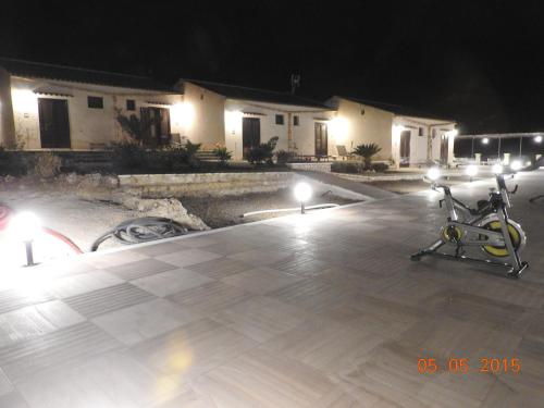 a bike parked in a parking lot at night at Hotel Antica Cascina Del Golfo in Scopello