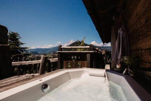 a bath tub with a view of the mountains at Chaletdorf BERGHERZ in Sankt Johann im Pongau