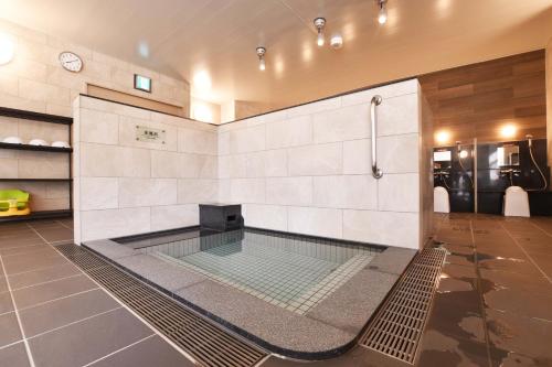 a bath room with a shower and a sink at Nayoro Onsen Sunpillar in Nayoro