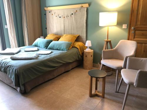 Un dormitorio con una cama y una mesa y sillas. en Gîte de Notre Dame, en Saint-Étienne-du-Grès