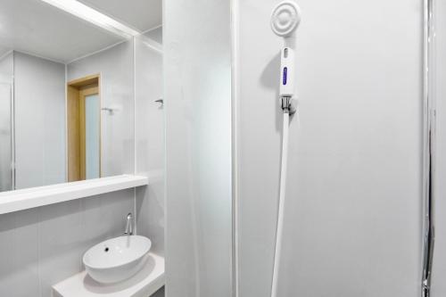 a white bathroom with a sink and a shower at Hotel POCO Seongsu in Seoul