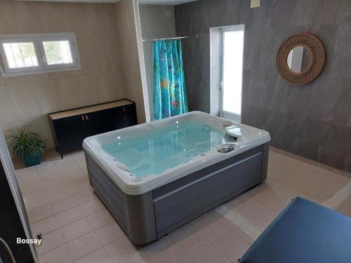 a large bath tub in a bathroom with a window at Chambres d'Hôtes L'Insulaire in Saint-Denis-dʼOléron