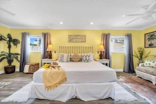 a large bedroom with a large bed and yellow walls at Deerfield Retreat! Walk to the Beach! Sleeps 8! in Deerfield Beach