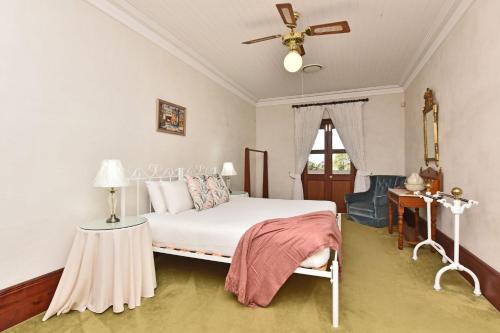 - une chambre avec un lit et un ventilateur de plafond dans l'établissement Paradise Manor on Serene Paradise Estate, à Luskintyre