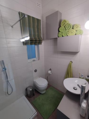 a white bathroom with a toilet and a sink at The Luxury Home - Next to airport! in Kirkop