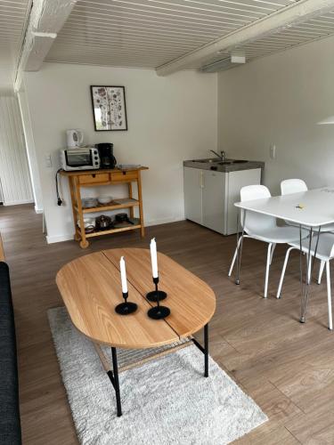 a living room with a table with three candles on it at Vejskrækgården in Fæbæk