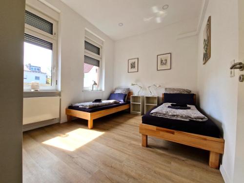 Burgunder - helle und ruhige Wohnung in Uninähe في ماينز: غرفة نوم بها سريرين ونافذة