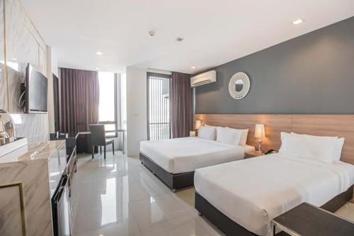 a hotel room with two beds and a kitchen at Marigold Sukhumvit - Free Shuttle to BTS Bearing Station in Bangkok