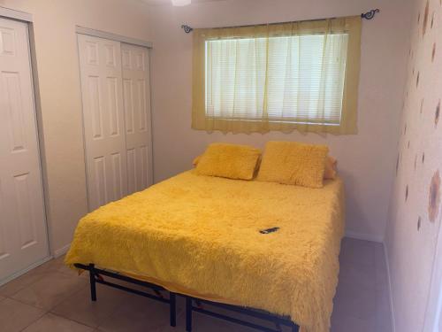 - une chambre avec un lit et une couverture jaune dans l'établissement Birdys Nest, à Las Vegas