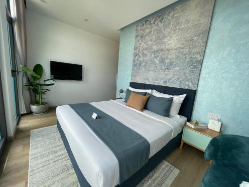 1 dormitorio con 1 cama grande y pared azul en xxx, en Vung Tau