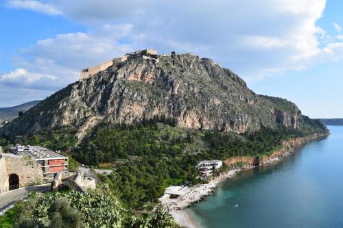 a mountain with a castle on it next to the water at Didis Place Nafplio in Nafplio