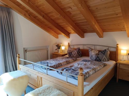 una camera con un grande letto e un soffitto in legno di Rabenhorst a Ofterschwang