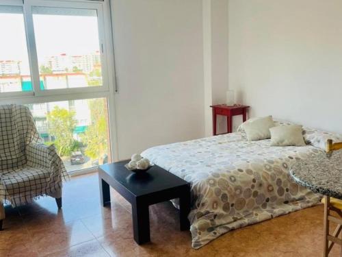 a bedroom with a bed and a chair and a window at Reconnectar Malgrat de Mar Colom I in Malgrat de Mar