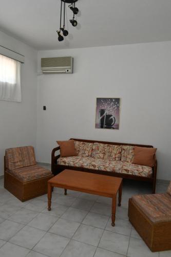 a living room with a couch and a table at Niki Hotel Apartments in Ialyssos