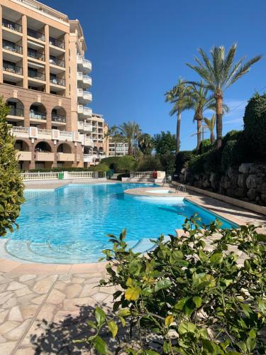 une grande piscine devant un immeuble dans l'établissement LE PALM AZUR - vue mer sur les iles de Lérins, à Cannes