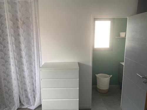 La salle de bains est pourvue d'une commode blanche et d'une fenêtre. dans l'établissement L' étoile de mer logement 3, à Sainte-Marie-la-Mer