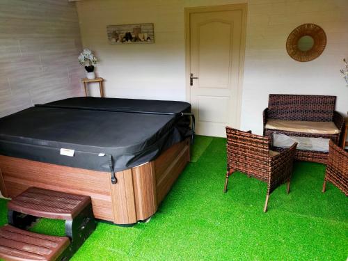 a room with a tub and two chairs and grass at Chambre d'hôtes Comme une évidence in Clairvaux-les-Lacs