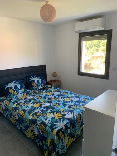 une chambre avec un lit avec une couette bleue et une fenêtre dans l'établissement L' étoile de mer logement 3, à Sainte-Marie-la-Mer