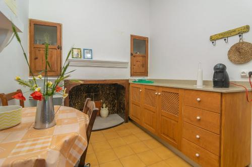 eine Küche mit einem Tisch und einer Theke mit einem Kamin in der Unterkunft Can Forner in Maria de la Salut