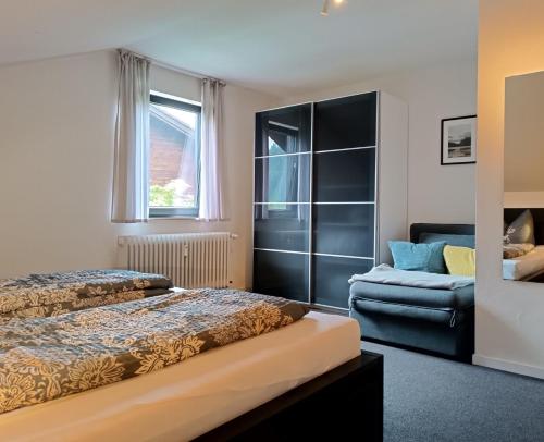 - une chambre avec un lit et une chaise dans l'établissement Alpenrose, à Obermaiselstein