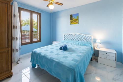 a blue bedroom with a bed and a window at Casa Meli Finestrat in Finestrat