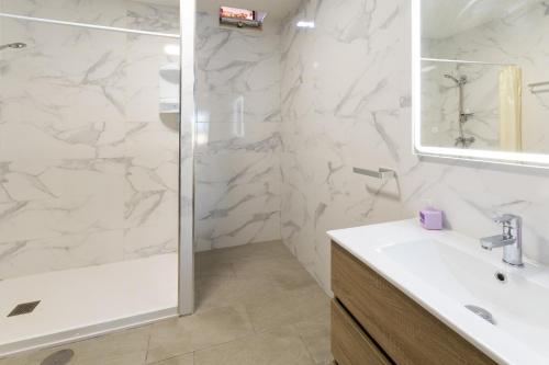 a white bathroom with a shower and a sink at Casa Meli Finestrat in Finestrat