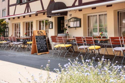 a restaurant with chairs and a table with a chalkboard at Hotel Sonnenstube Hagnau in Hagnau