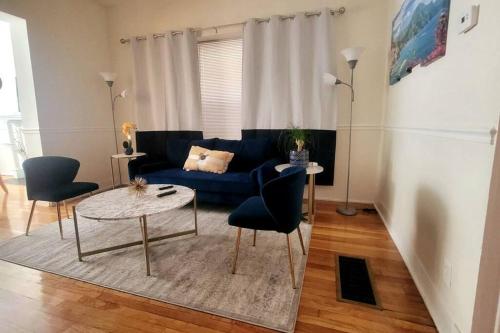 a living room with a blue couch and two chairs at Chateau de Woodlawn - Peaceful 3 bedroom apartment. in Chicago
