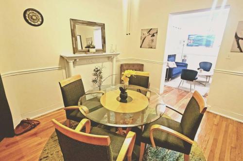 a dining room with a glass table and chairs at Chateau de Woodlawn - Peaceful 3 bedroom apartment. in Chicago