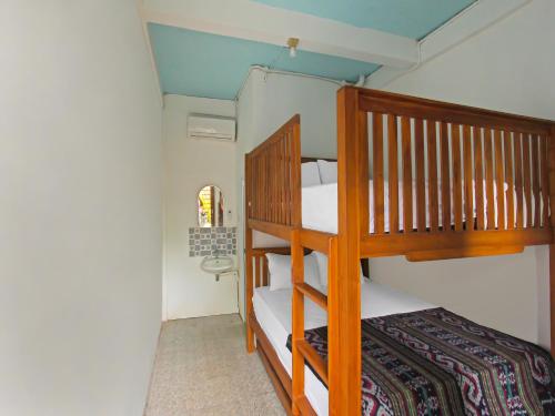 OYO 92558 Bale Datu Homestay في Montongbuwoh: غرفة نوم بسريرين بطابقين وسرير