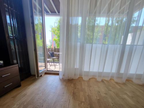 a living room with white curtains and a sliding glass door at Kastani Home in Tartu