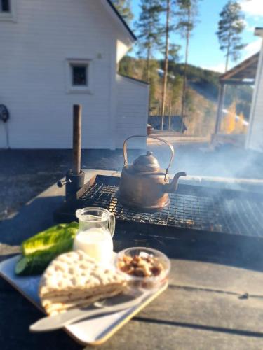 un hervidor de agua y un plato de comida a la parrilla en Stuga i Storklinten, en Harads