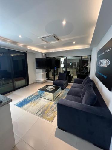 a living room with a couch and a television at Suite Exclusiva frente al mar Hotel Poseidón Manta in Manta